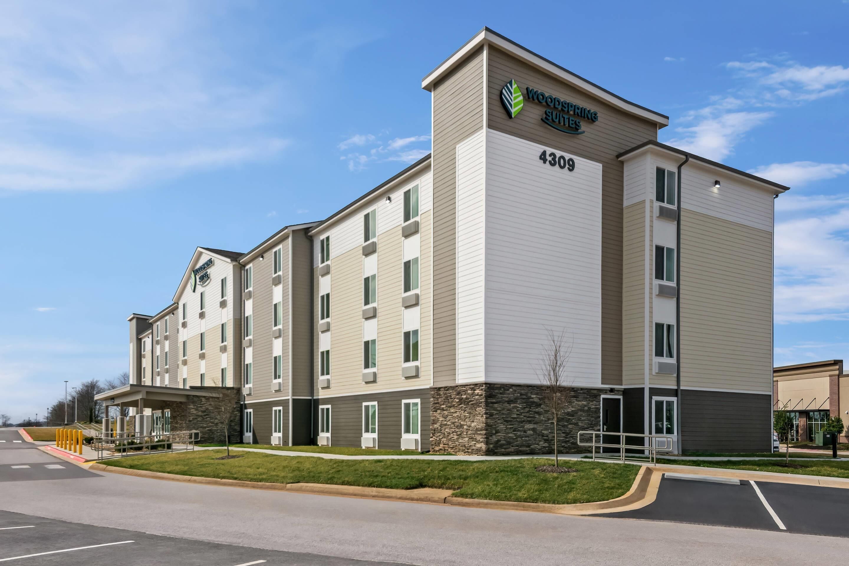 A multi-story hotel with a modern design, featuring a prominent logo and the address 4309.