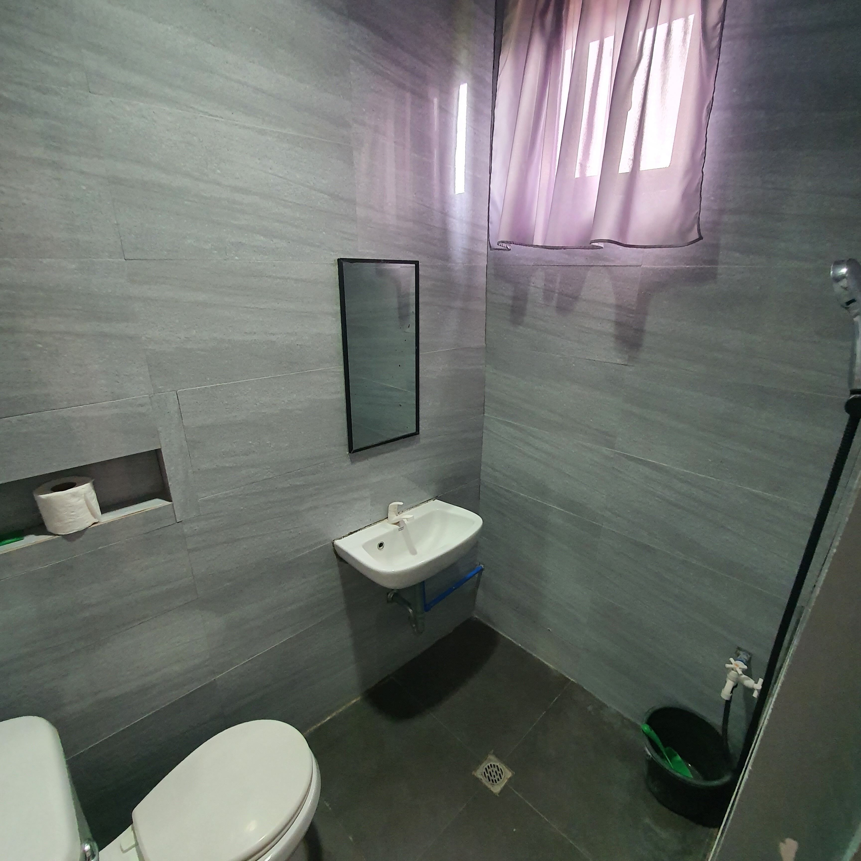 A bathroom with a toilet, sink, and shower.