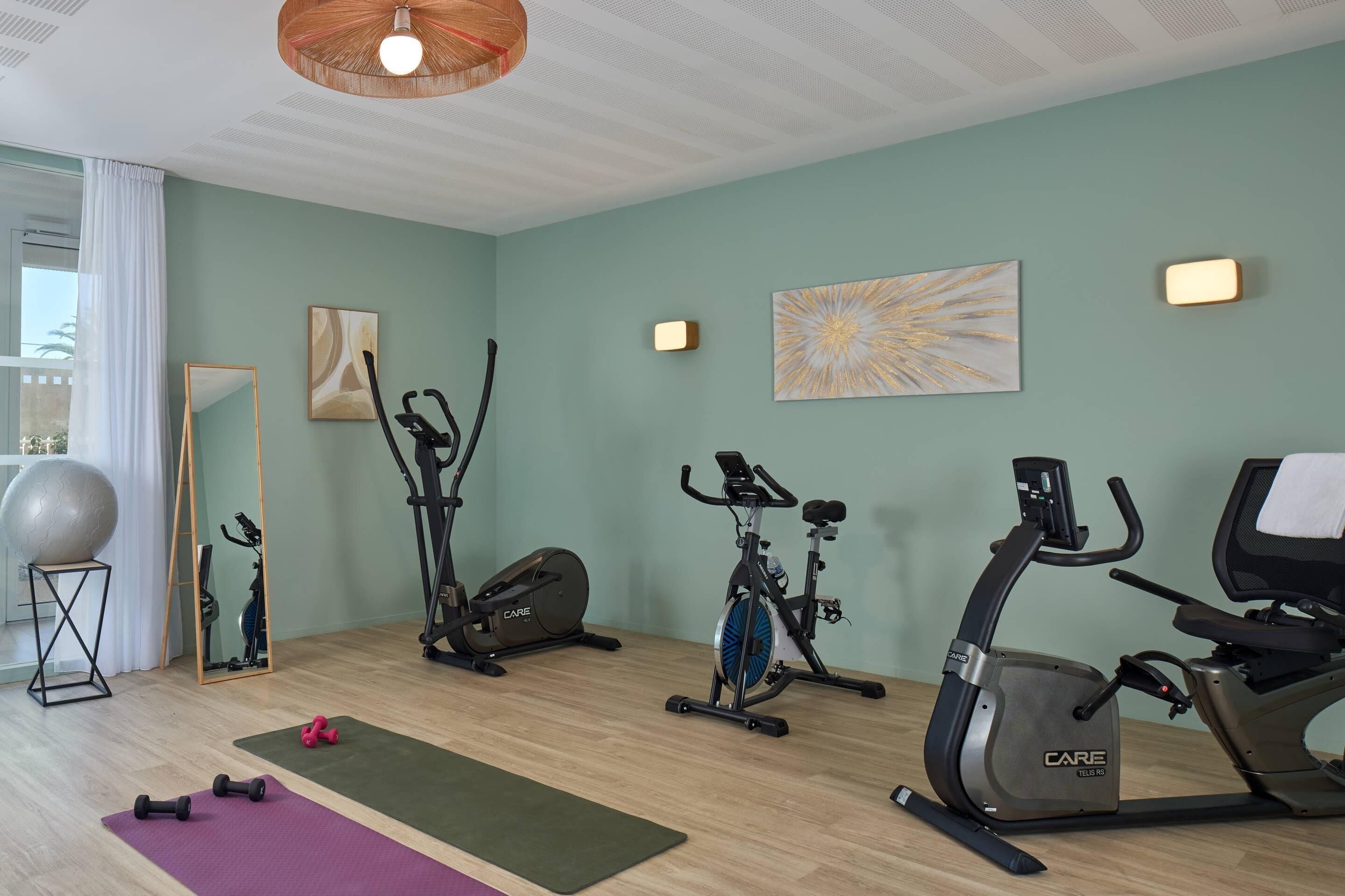 A home gym with exercise equipment, a yoga mat, and a mirror.