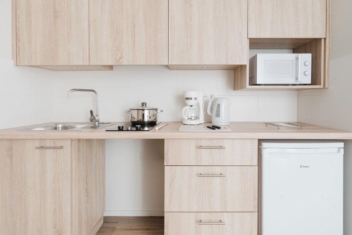 A kitchen with wooden cabinets, a microwave, a coffee maker, and a dishwasher.