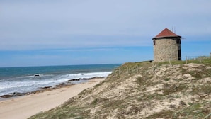 A coastal view with two stone towers and a sandy beach. - Apartment Apulia - sea view 6 people (Apúlia esposende)