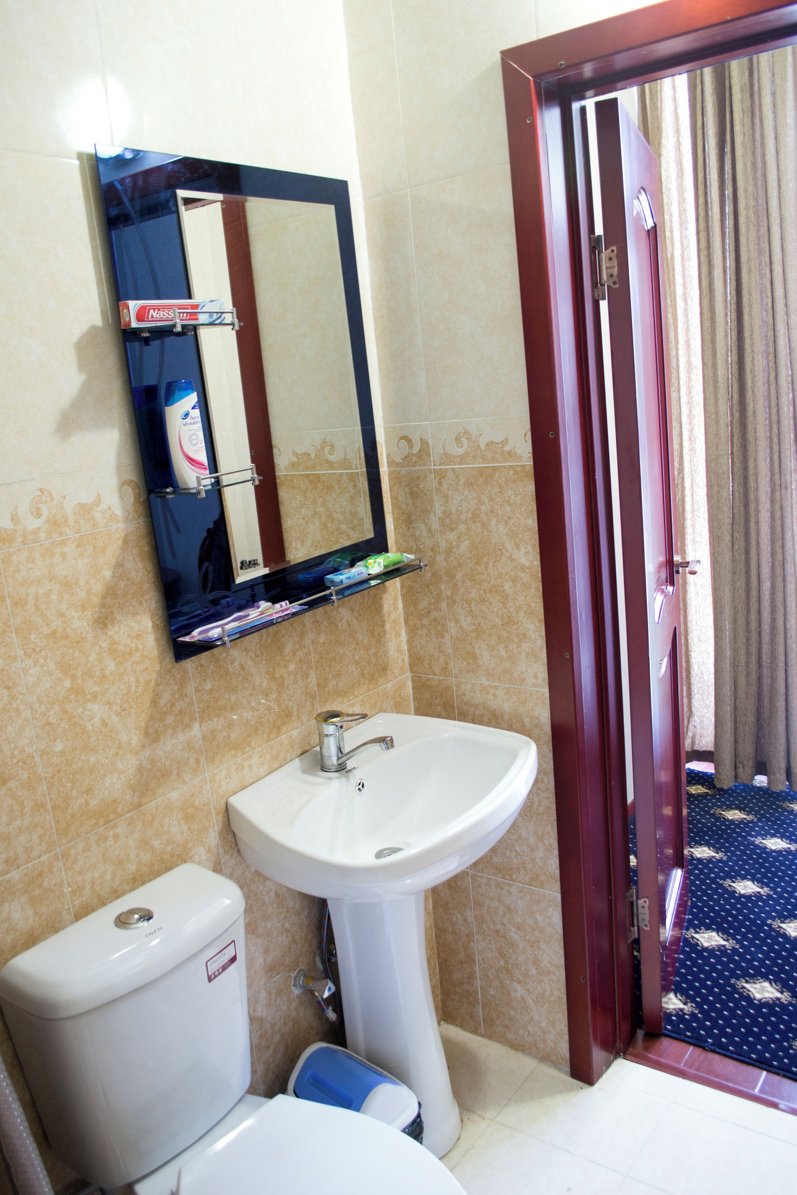 A bathroom with a white sink, a mirror, and a toilet.