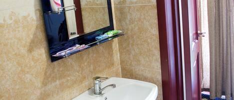 A bathroom with a white sink, a mirror, and a toilet.