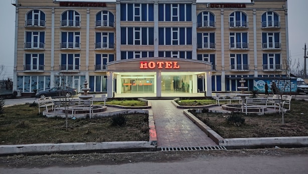 Un hotel con un llamativo letrero que dice 'HOTEL', varios balcones y una entrada central.
