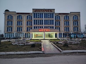 A hotel with a prominent 'HOTEL' sign, multiple balconies, and a central entrance. - Bokhtariyon Hotel (Qurghonteppa)