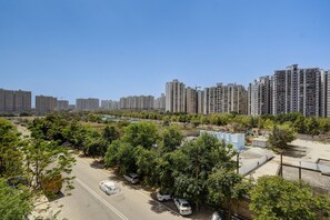 Un quartier résidentiel comprenant des immeubles d’habitation à étages élevés, un parking et des espaces verts.