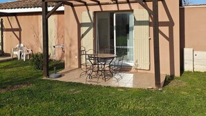 A covered patio area with a table and chairs, a pergola, and a glass door leading to an interior space. - 🌟 Casa Luna 🌟 (Saint-Saturnin-lès-Avignon)