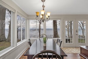 Enjoy meals with a view of the water from this dining area, featuring a large table for four and a beautiful view.
