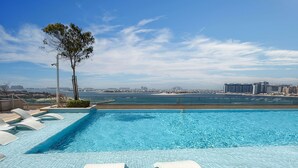 A swimming pool with a view of the city skyline and a body of water in the background. - LUX The Beach Vista Dubai Eye View Suite (Dubai)