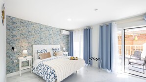Un dormitorio con cama, mesita de noche y vistas al exterior.