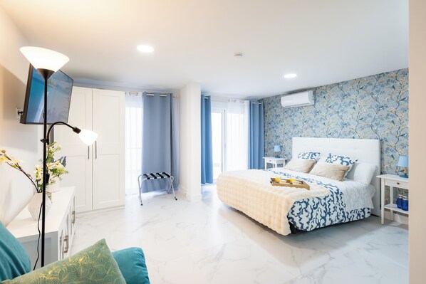 A bedroom with a bed, bedside table, lamp, and a view of the outside. - Bety Dreams Apartments (Madrid)