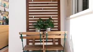 A wooden bench with a metal frame, positioned in front of a window with horizontal blinds. - Mamuccia Rooms (Naples)