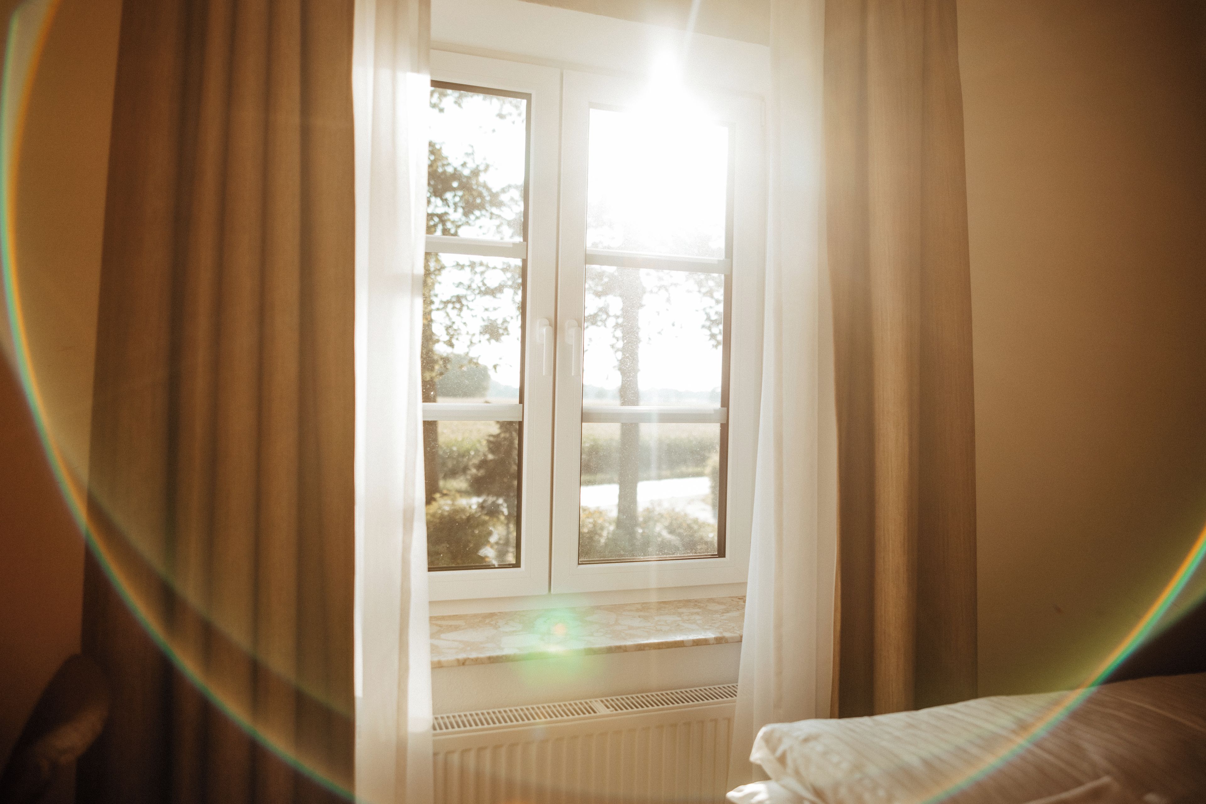 Une pièce avec une fenêtre, un radiateur et un lit.
