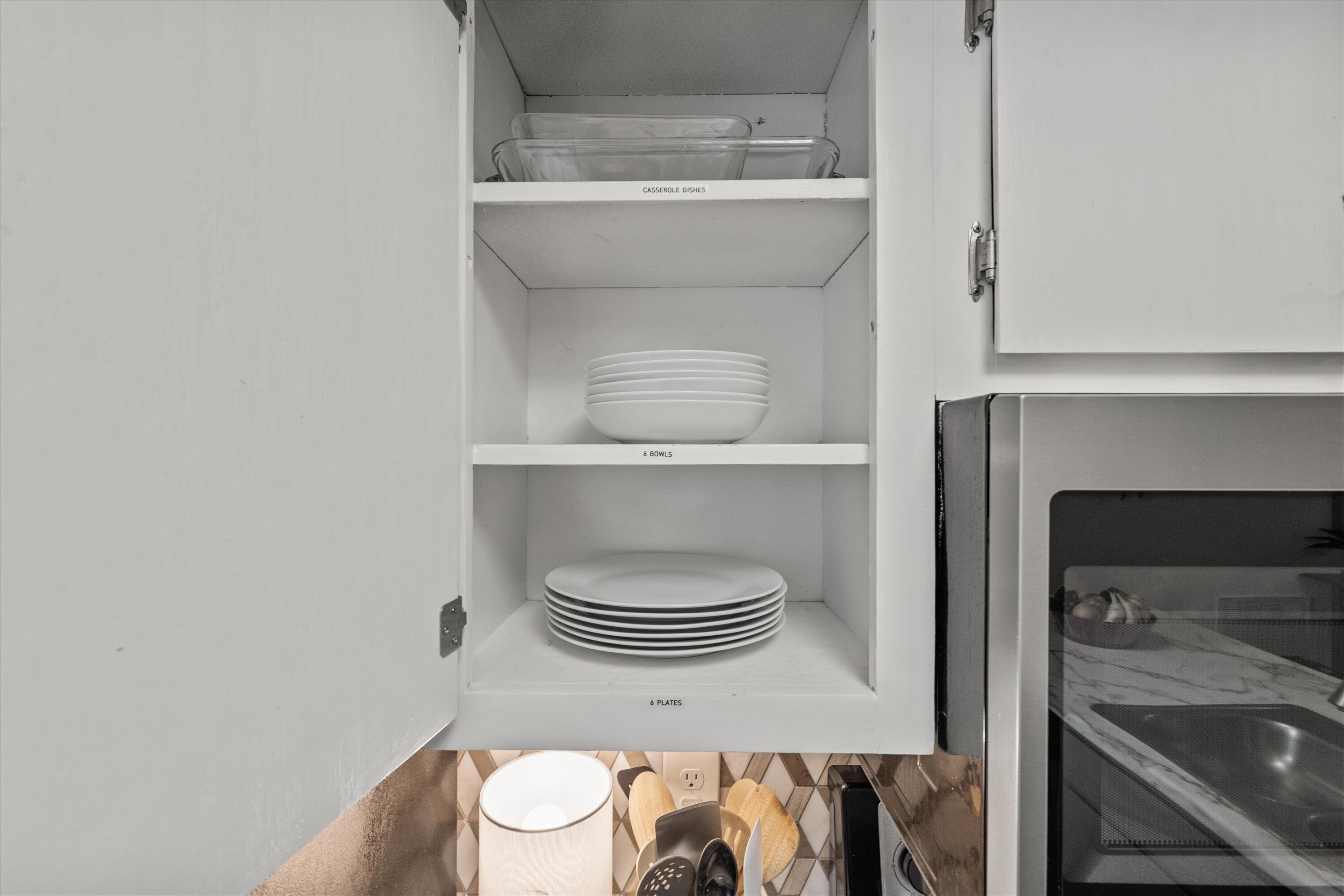 A kitchen with white cabinets, a microwave, and a sink.