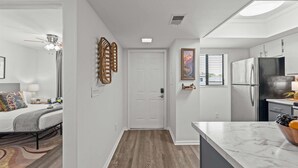 A modern apartment with a kitchen, a dining area, and a bedroom.
