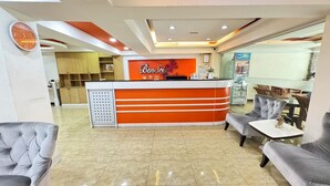 A reception area with a modern design, featuring a reception desk, seating area, and a clock on the wall. - Bensri Residence Pattaya (Pattaya)