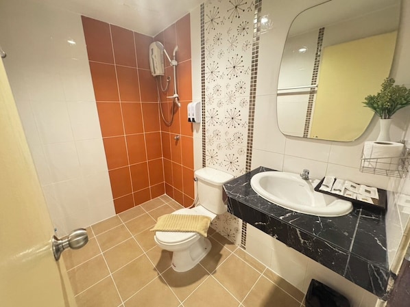A bathroom with a toilet, a sink, and a shower. - Bensri Residence Pattaya (Pattaya)