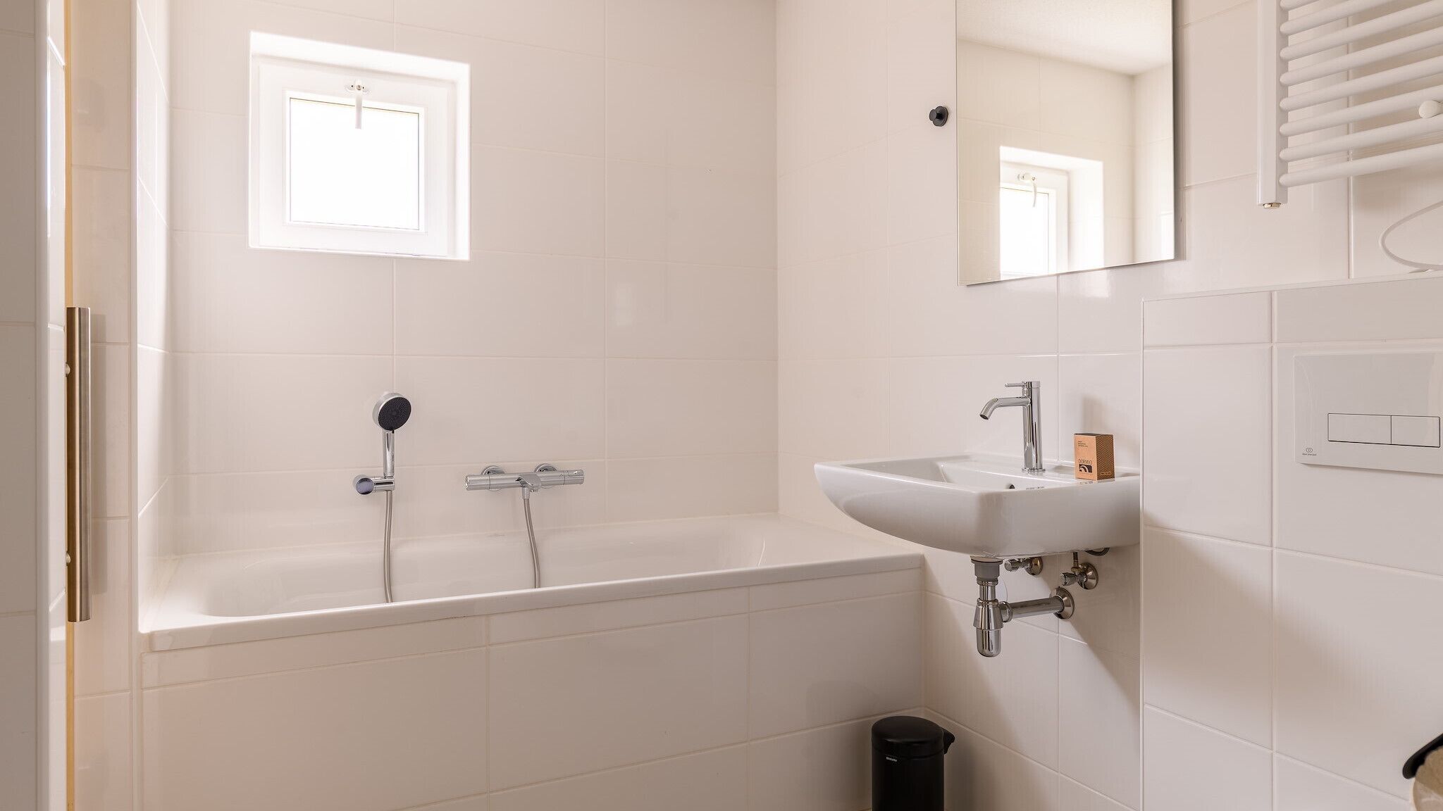 Un bagno moderno con vasca, lavabo e specchio.