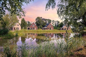 Une propriété située au bord d’un lac, comprenant trois maisons, un étang et de nombreux espaces verts.