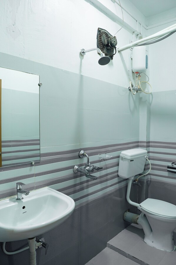 A bathroom with a sink, toilet, and a mirror. - Ocean View (Port Blair)