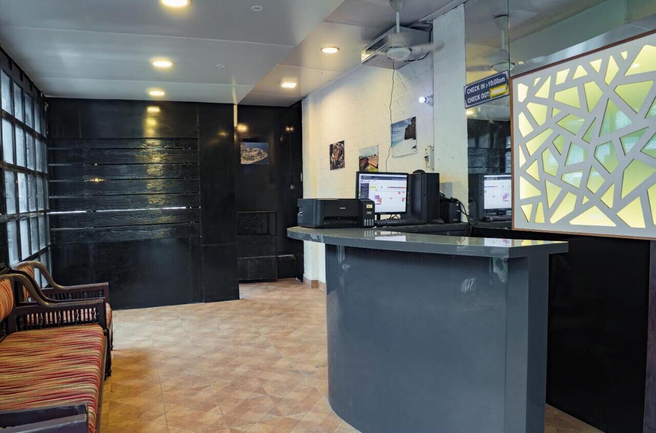 A reception area with a counter, computer, and seating.