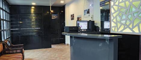 A reception area with a counter, computer, and seating.