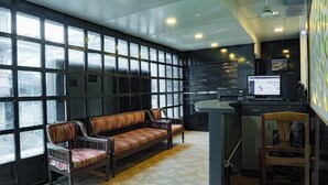 A reception area with a bench, a desk, and a computer monitor. - Ocean View (Port Blair)