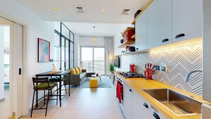 Una cocina moderna con una isla central, electrodomésticos integrados y un salpicadero con motivo de espiga.