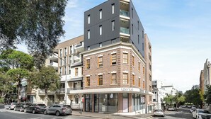 A modern building with a mix of brick and grey facade, featuring a dental clinic on the ground floor.