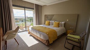 A hotel room with a large bed, a view of the outdoors, a chair, and a small table. - 
THE RIAD PEARL OF MARRAKECH (Jdid)