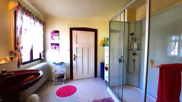 Une salle de bain avec une douche à parois de verre, un lavabo et des toilettes.