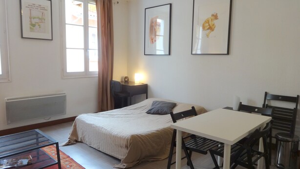 A hotel room with a bed, a desk, a chair, and a radiator. - Studio in Grenoble city center (Grenoble)