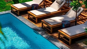 A swimming pool with wooden deck and lounge chairs. - Doudou Hotel by Dina Mogarbine (Saint-Paul)