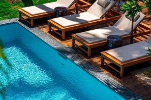 Una piscina al aire libre, tumbonas