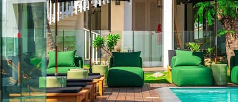 Una piscina al aire libre, sillones reclinables de piscina