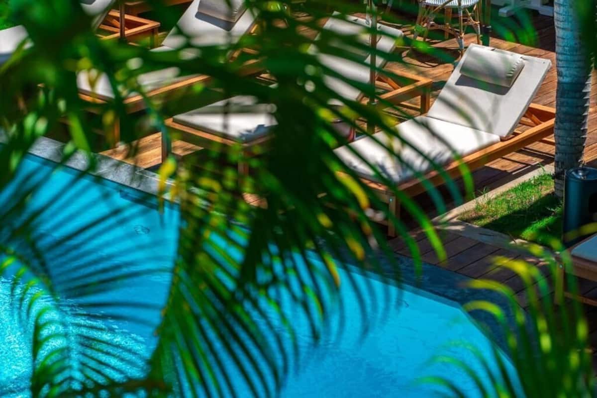 A poolside area with lounge chairs and a wooden deck.