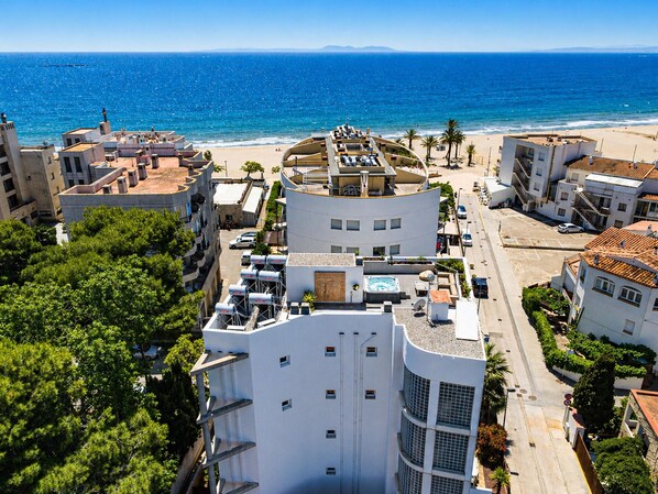 A coastal urban area with buildings, a beach, and a clear sky.