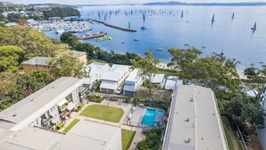 Zona residencial com casas modernas, uma piscina e uma marina com veleiros.