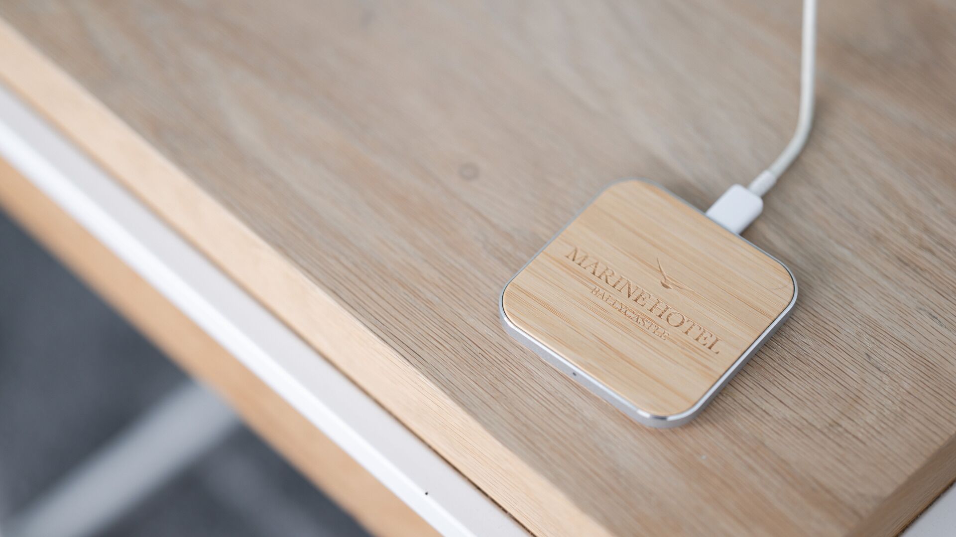 Une station de recharge en bois sur laquelle est inscrit le texte « MARINE HOTEL ».