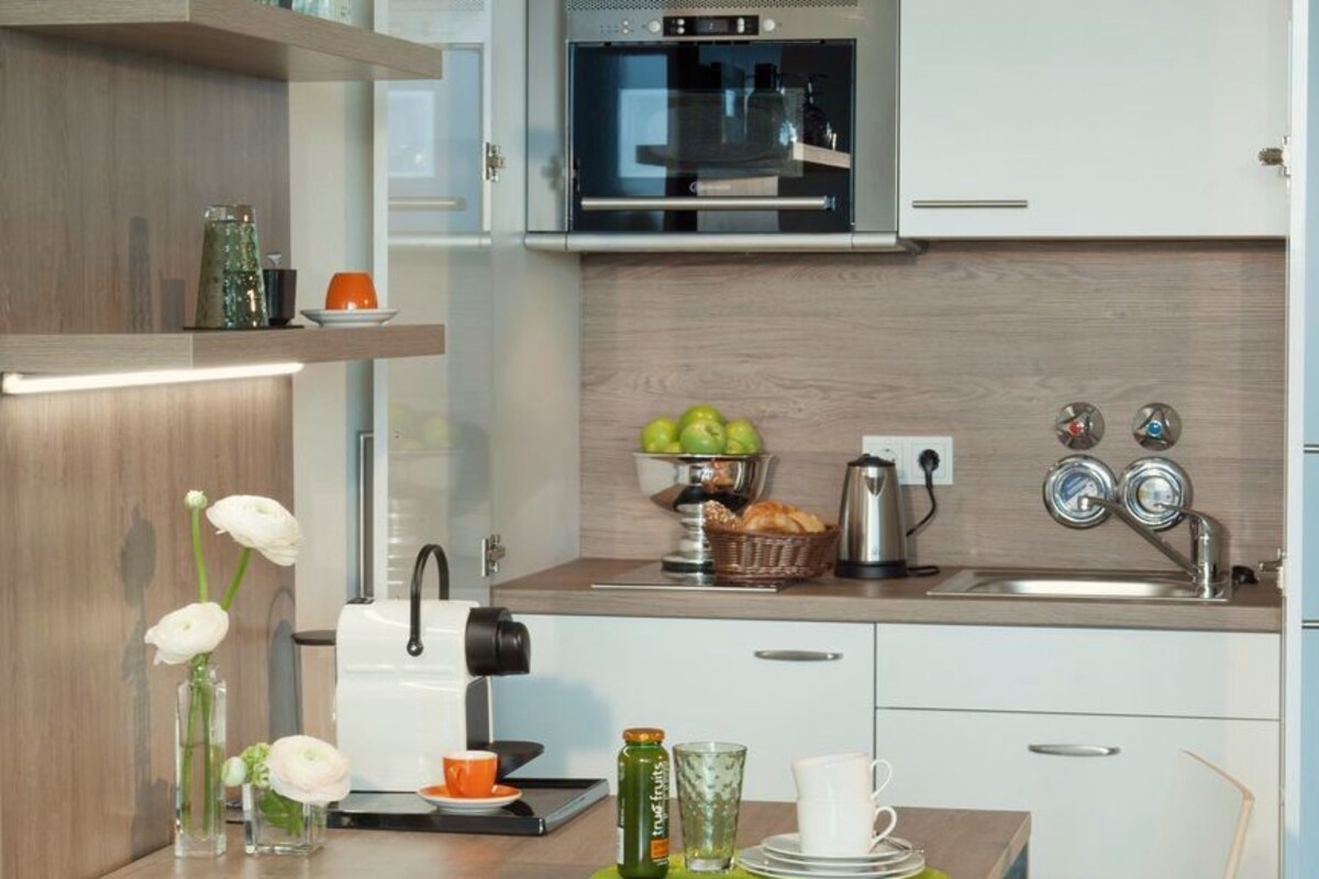 A compact kitchen with a microwave, sink, and a small dining area with a table and chairs.