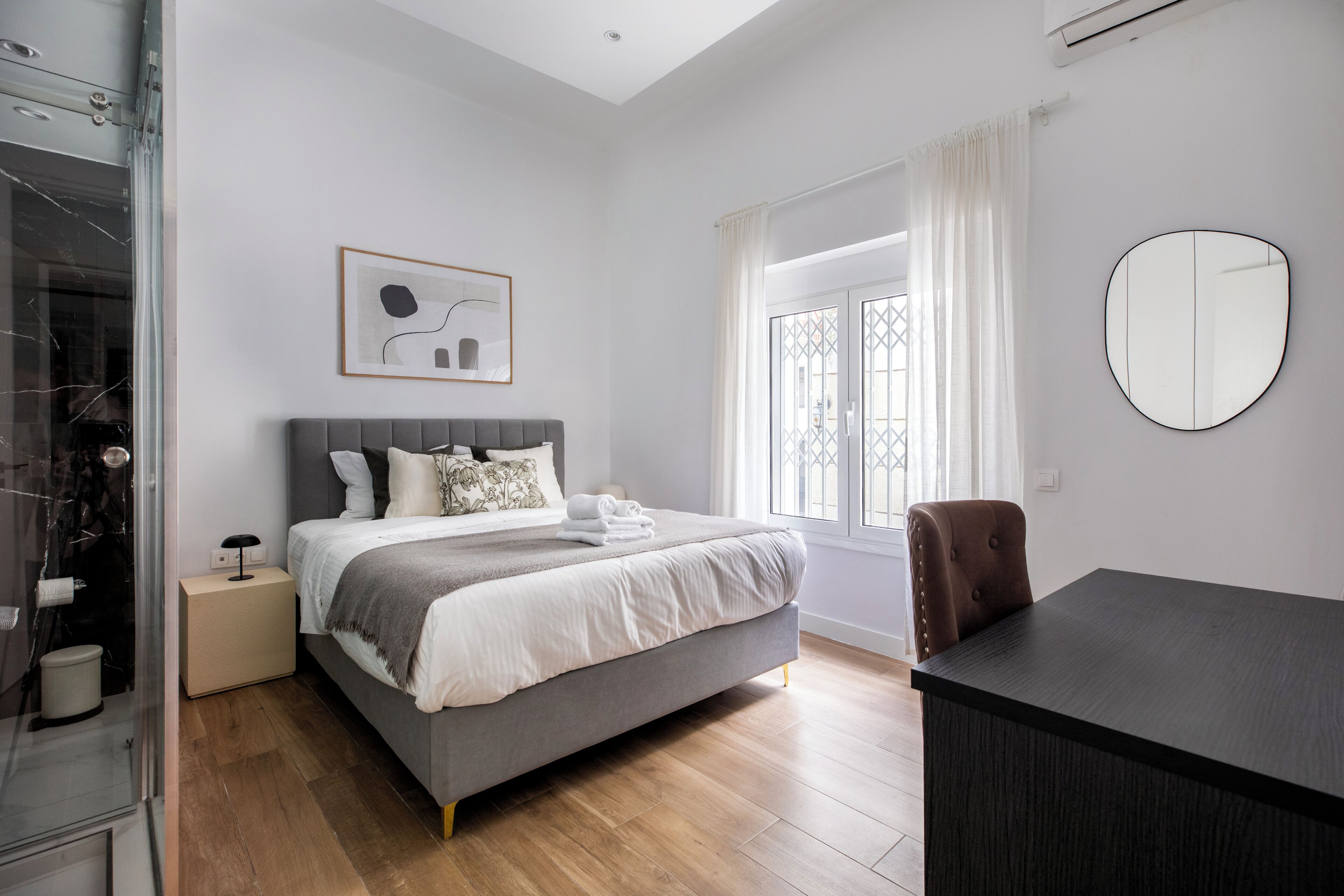 Une chambre à coucher moderne avec un lit, une table de chevet et un bureau.