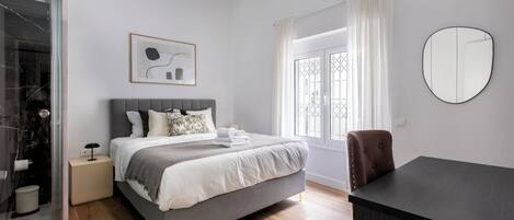 Une chambre à coucher moderne avec un lit, une table de chevet et un bureau.
