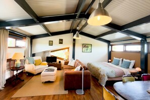 A spacious room with a high ceiling, a bed, a sofa, a desk, and a television. - Hestar Husid, a designer home with a garden near Amsterdam (Weesp)