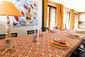A dining room with a table set for four, featuring a patterned tablecloth, candles, and a starfish centerpiece. - Hestar Husid, a designer home with a garden near Amsterdam (Weesp)