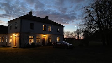 Ett tvåvåningshus med en uppfart och en parkerad bil.