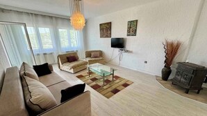 Uma sala de estar moderna com sofá, mesa de centro e televisão.