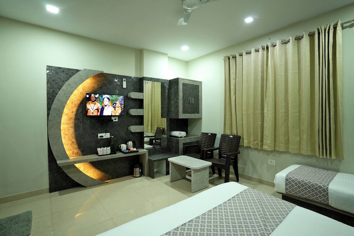 Una habitación de hotel moderna con televisión, zona de estar y un minibar.