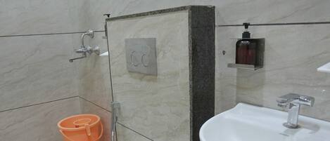 A bathroom with a toilet, sink, and shower.