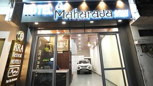 A hotel named "Hotel Maharaja Stay" with a modern facade, large glass entrance, and a visible car parked inside. - RRA Retreat Hotel (Nathdwara)