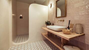 A modern bathroom with a freestanding bathtub, a wooden vanity with a sink, and a large mirror.